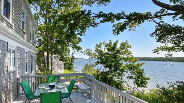 A deck with a table and chairs, overlooking a lake. - Waterfront on the Cove, NEW Kitchen and Central AC (Orleans)