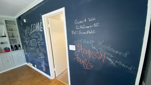 A room with a wooden floor, a white door, and a chalkboard wall with writing. - 12th Green at Duncan Golf Club and Tennis Club (Duncan)