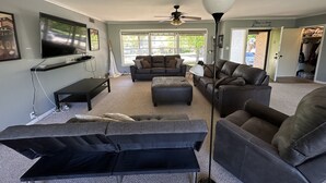 A living room with a television, sofas, a coffee table, and a ceiling fan. - 12th Green at Duncan Golf Club and Tennis Club (Duncan)