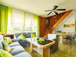 Relax in this stylish living room with a sofa, coffee table, and staircase leading to an upper level.