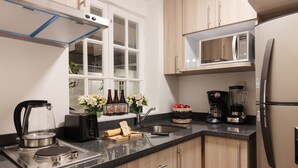 A modern kitchen with stainless steel appliances, wooden cabinets, and a window providing natural light.