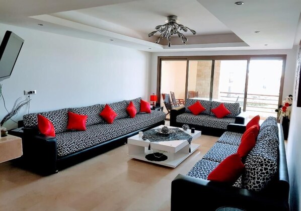 A modern living room with two sofas, a coffee table, and a ceiling light.