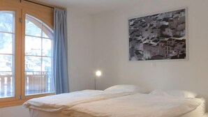 Una camera da letto con un letto, una finestra con tende e una lampada a parete.