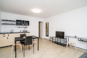 A modern kitchen with a dining area, a TV, and a mirror. - Residence & Pool Villa Schwarz Suites - Standard One Bedroom Apartment (Cavtat)