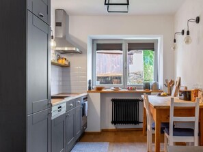 Een koelkast, een oven, een vaatwasser, kookgerei, borden en bestek