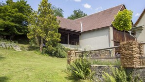 Een huis met een schuin dak, een stenen fundering en een verzorgd gazon.