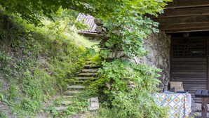 Een landelijke stenen trap die leidt naar een houten gebouw met een overdekte veranda.