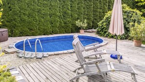 A backyard with a wooden deck, a swimming pool, and a tall hedge. - Zábřeh-Lukavice 1 by Interhome (Zabreh)