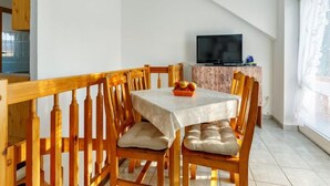 Ein Essbereich mit Tisch, Stühlen und einem Fernseher auf einem Holzschrank.