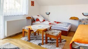 A cozy bedroom with a bed, a wooden table, a chair, and a small table with a tablecloth. - Apartment Renata by Interhome (Balatonmariafurdo)