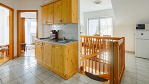 Eine geräumige Küche mit Holzausstattung, eingebautem Spülbecken und einem Essbereich mit Holztisch und Stühlen.