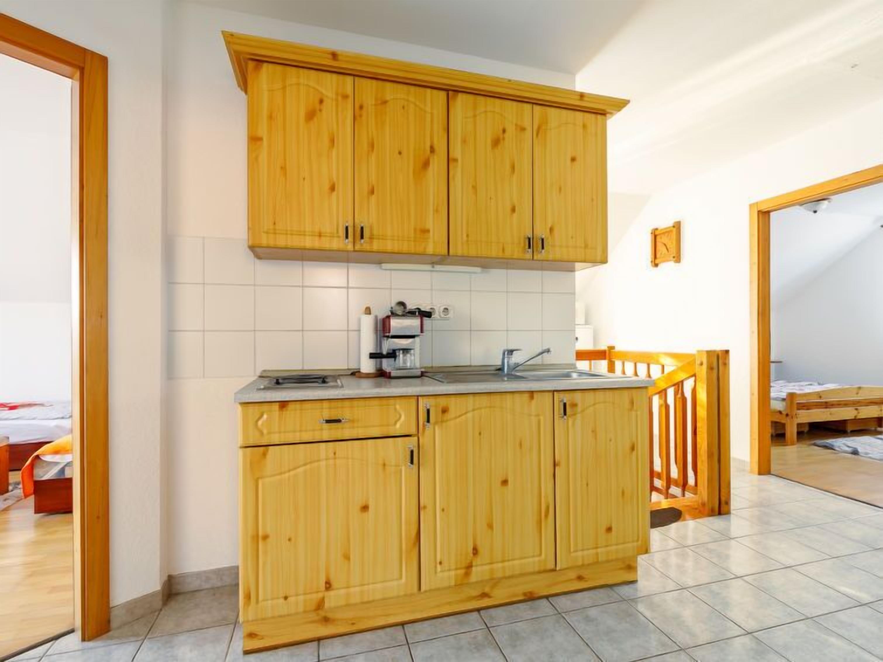 Une cuisine avec des meubles en bois, une machine à café et un évier.