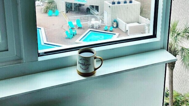A view of a beachside hotel with a pool, lounge chairs, and a clear view of the ocean. - 4th floor beachfront studio with two queens (Panama City Beach)