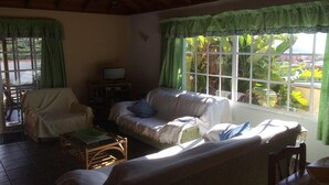 A cozy living room with a sofa, armchairs, a television, and a window with curtains. - Casa Oscar (Los Llanos de Aridane)