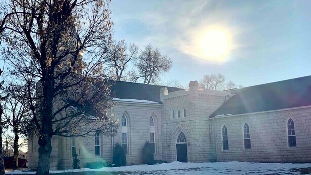 A large, historic building with arched windows and a symmetrical facade, surrounded by snow. - Jailer`s Cottage | 130-Year-Old Gem | Sleeps 12 (Spring City)