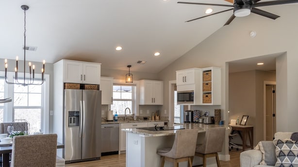 A modern kitchen with white cabinets, a stainless steel refrigerator, and a central island with bar stools. - Hot Tub, Cozy, Central Air and Heat, 5 minutes to the Ski Resort! Yes, Deer!  (Beech Mountain)
