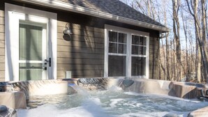 A hot tub area with a wooden deck, a door, and a window. - Hot Tub, Cozy, Central Air and Heat, 5 minutes to the Ski Resort! Yes, Deer!  (Beech Mountain)