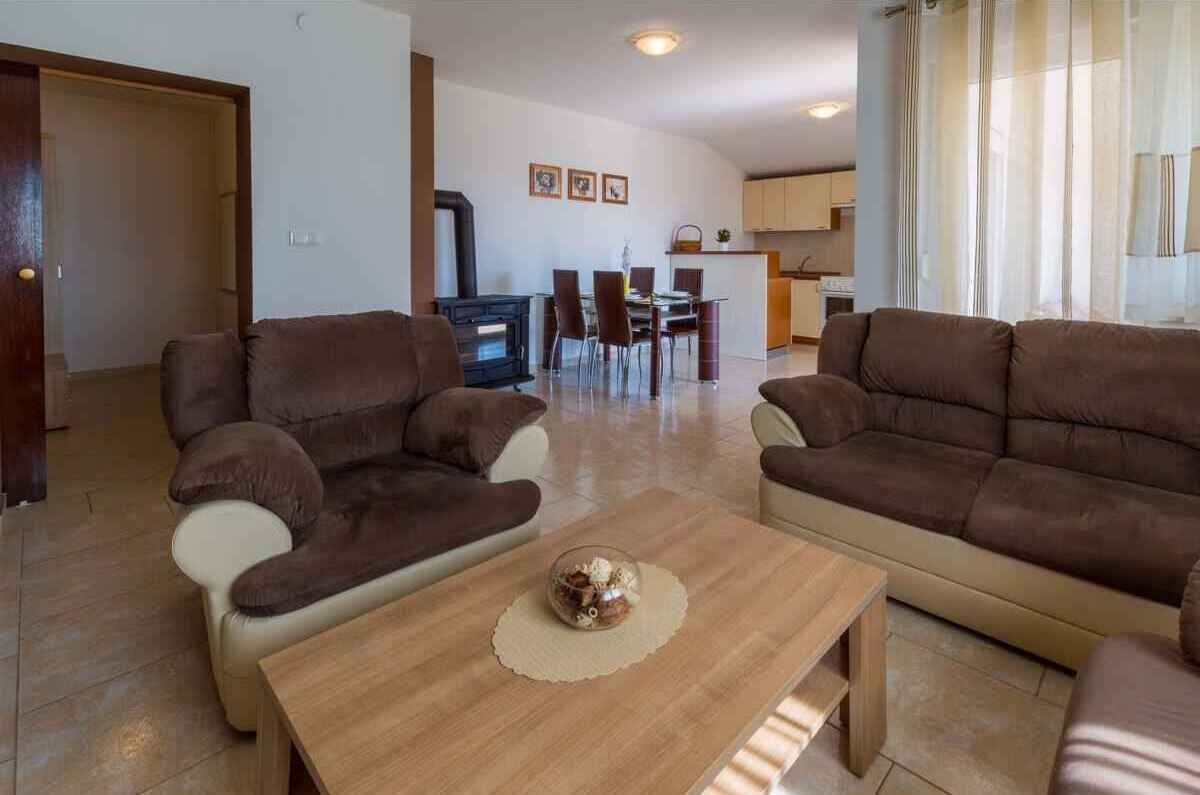 A living room with two sofas, a coffee table, and a dining area with chairs and a table.