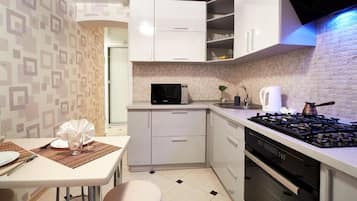 Standaard appartement | Privékeuken | Een koelkast/vriezer, een magnetron, een oven, een waterkoker