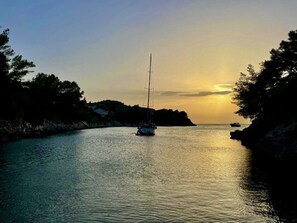 A sailboat on calm waters with a sunset in the background. - Apartment "Fantasy" with 2 bed rooms, terraces, swimming pool, jacuzzy. Sea view (Poplat Vela Luka)