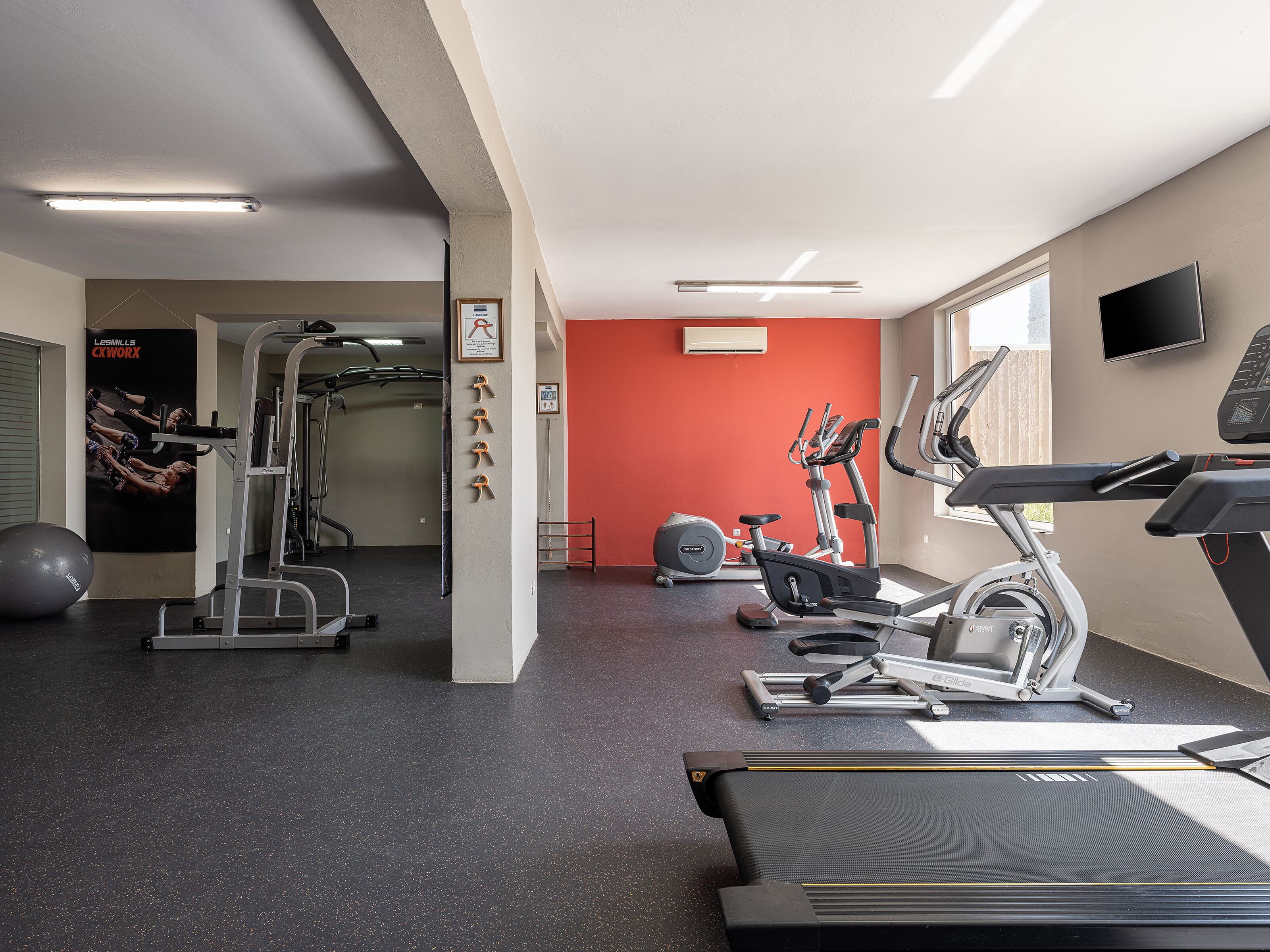 A gym with treadmills, stationary bikes, and weight machines.