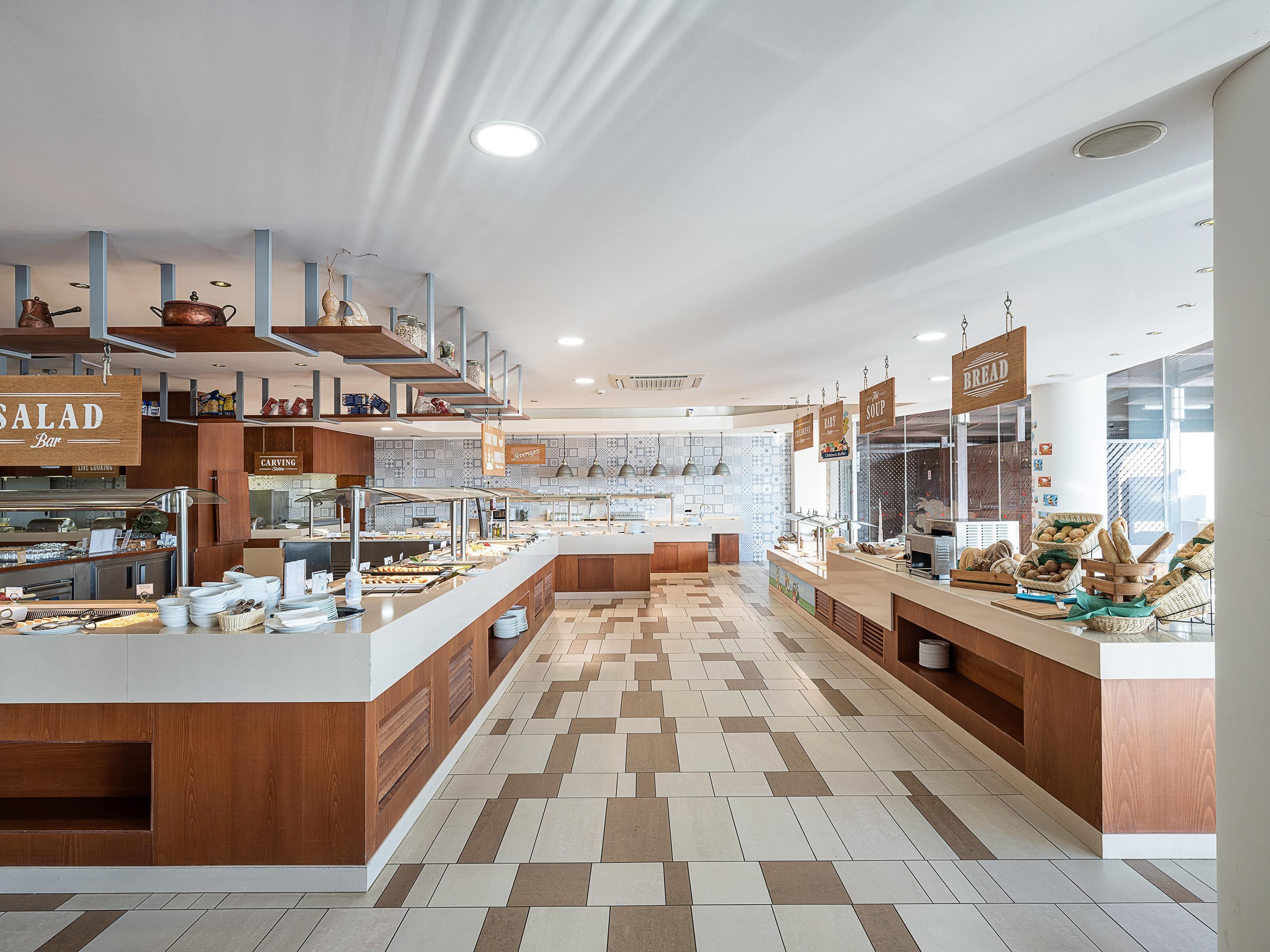 A modern buffet area with multiple food stations, including a salad bar and soup section, with a clean and organized layout.