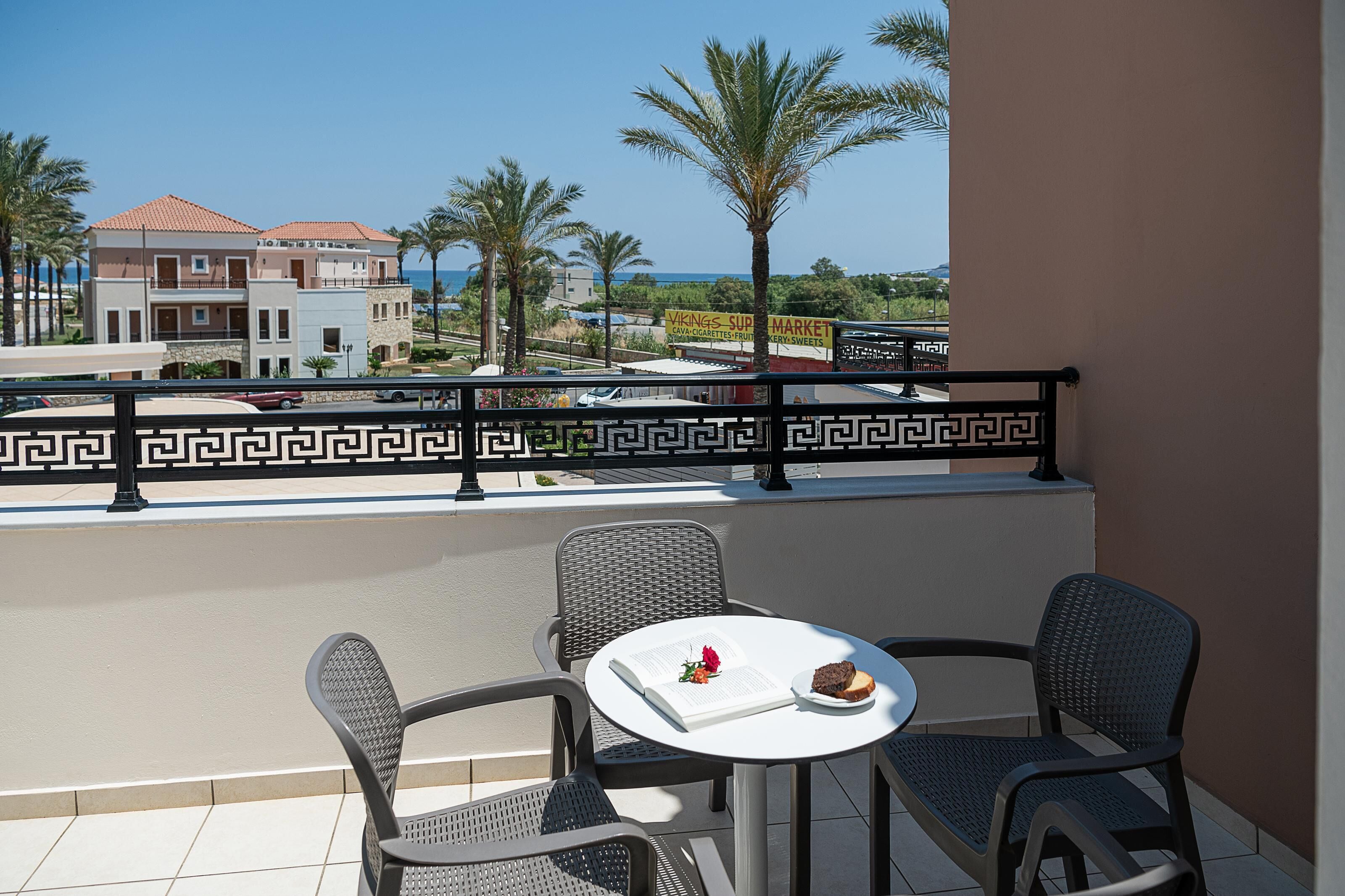 Un balcon avec une table, des chaises et un livre.