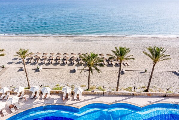 En la playa, sillas reclinables de playa, sombrillas, toallas de playa