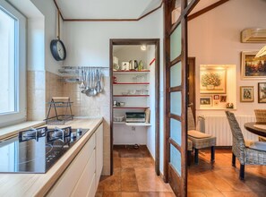 A kitchen with a stove, utensils, and a window. - Apartments Vrandecic (Postira)