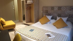 A hotel room with a bed, a chair, a wardrobe, and a desk. - Gite in the heart of the village (Belleville-sur-Loire)