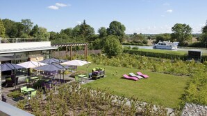 A patio area with outdoor seating and a view of a river. - Gite in the heart of the village (Belleville-sur-Loire)
