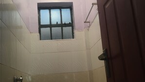 Une salle de bain avec une fenêtre, une douche et une porte.