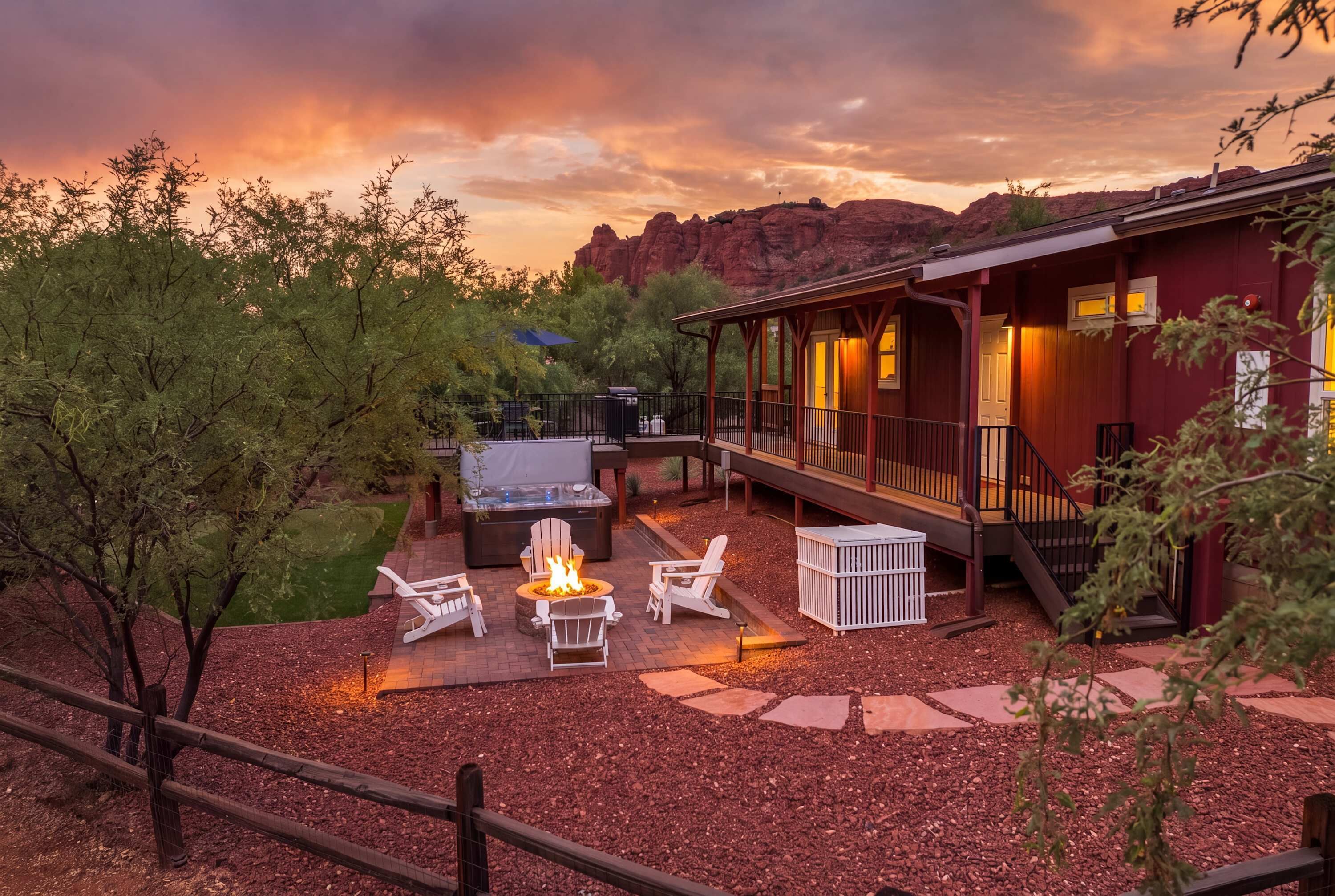 A lodge with a fire pit, outdoor seating, and a view of red rock formations.