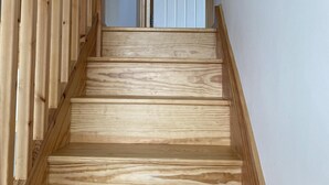 A wooden staircase with a handrail leading to a door. - Appletree (Isles of Scilly)