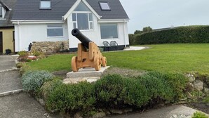 A house with a large black cannon in the front yard. - Appletree (Isles of Scilly)