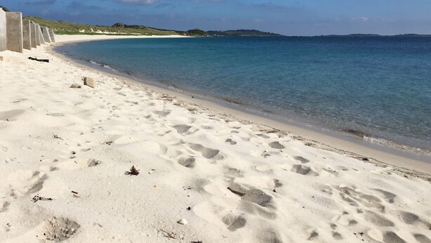 A sandy beach with footprints, a calm sea, and a clear sky. - Appletree (Isles of Scilly)