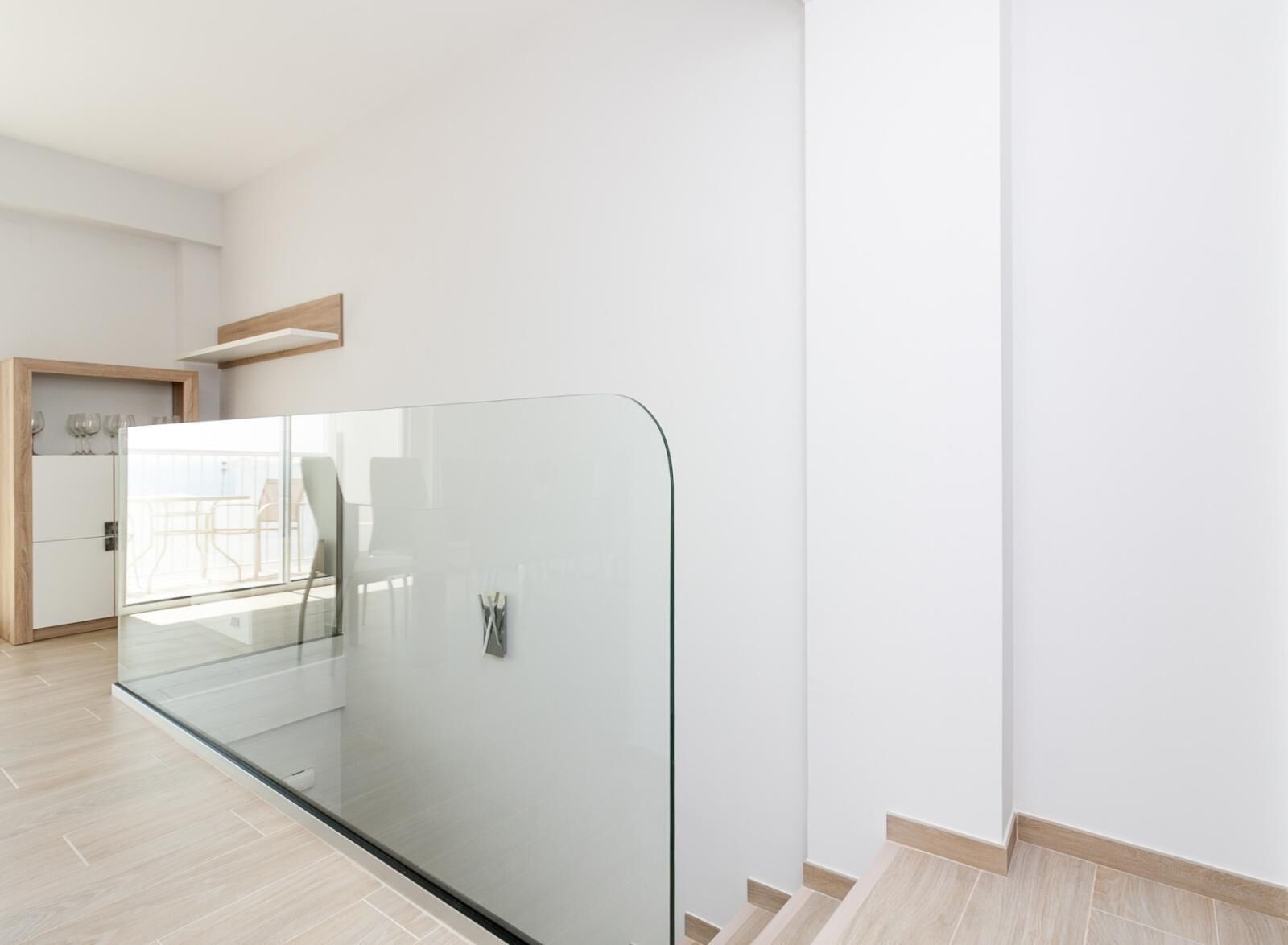 Ein modernes Hotelzimmer mit Glastrennwand, Holzboden und minimalistischem Design.