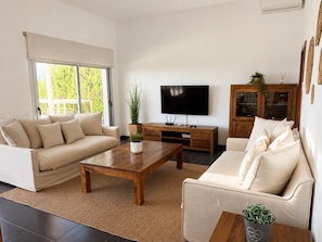 A modern living room with a sofa, a coffee table, a TV, and a cabinet.