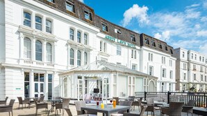 A hotel with outdoor seating and a covered patio area. - Abbey Lawn Hotel (Torquay)