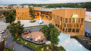 Ein modernes Hotel mit Innenhof, Außenbestuhlung und einem sichtbaren Amazon-Logo.