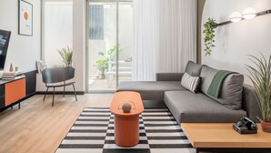 A modern living room with a sofa, a coffee table, a TV, and a bookshelf. - Mr. Montana - By TLV2GO (Tel Aviv)