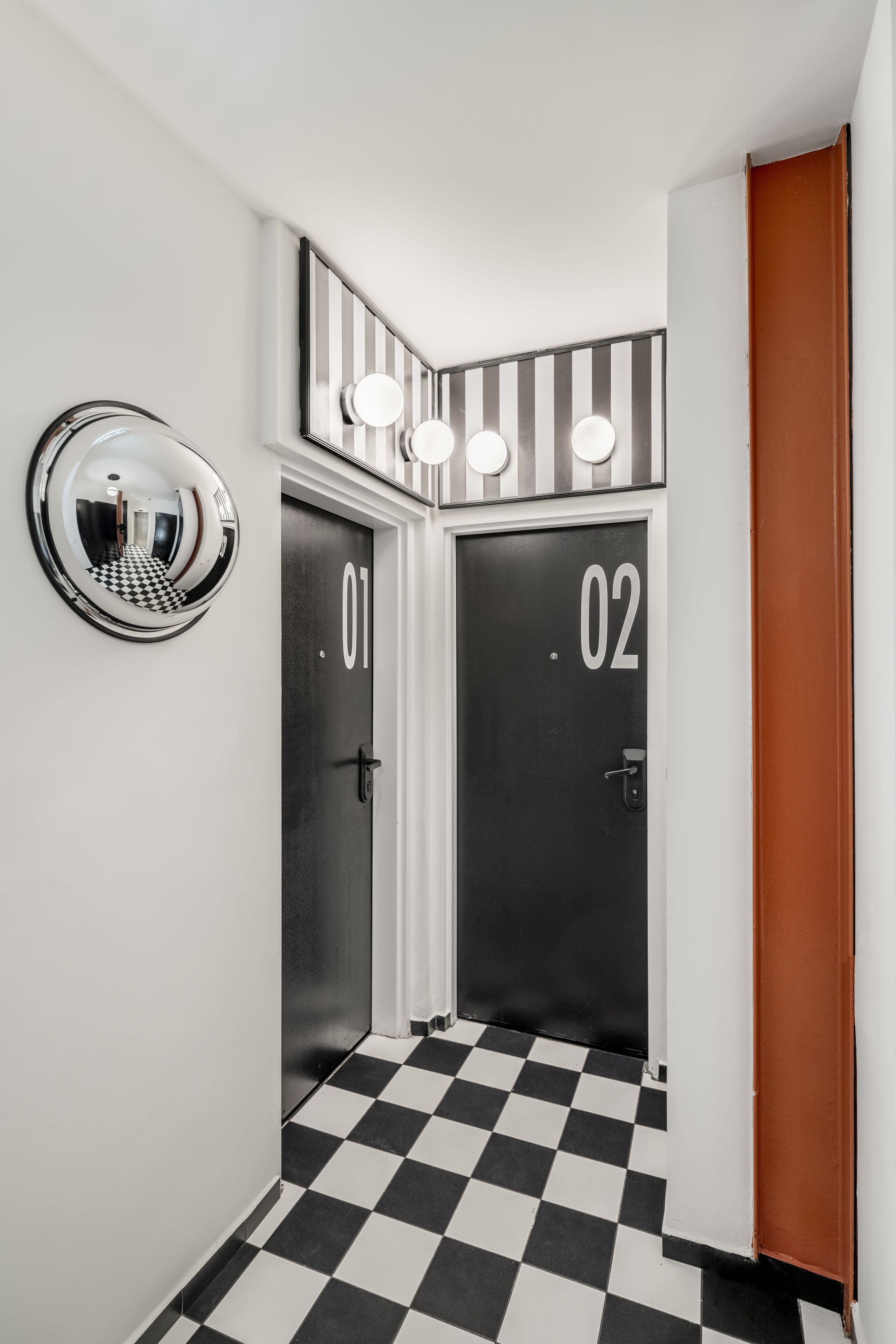 A hallway with two doors labeled 01 and 02, checkered floor, and a mirror on the wall.