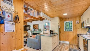 Un interior de madera con cocina, comedor y sofá.