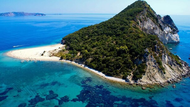 An aerial view of a coastal island with a beach, clear waters, and rocky terrain. - Private pool villa with water massage pool and sea view roof garden (zakynthos)
