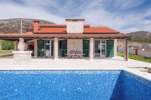 A house with a swimming pool, a patio with outdoor furniture, and a mountain backdrop. - Villa Dea (Vučevica)