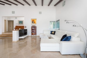 A modern living room with a white sofa, a TV on a stand, and a piano. - Villa Dea (Vučevica)