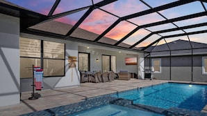 Piscina com teto de vidro, área de estar externa e placas de sinalização.