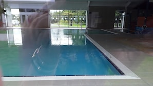 An indoor swimming pool with clear water, tiled floor, and a view of greenery outside. - 2 bed Caravan Approx 10 Mins From Beach Suzie 2 (Hull)
