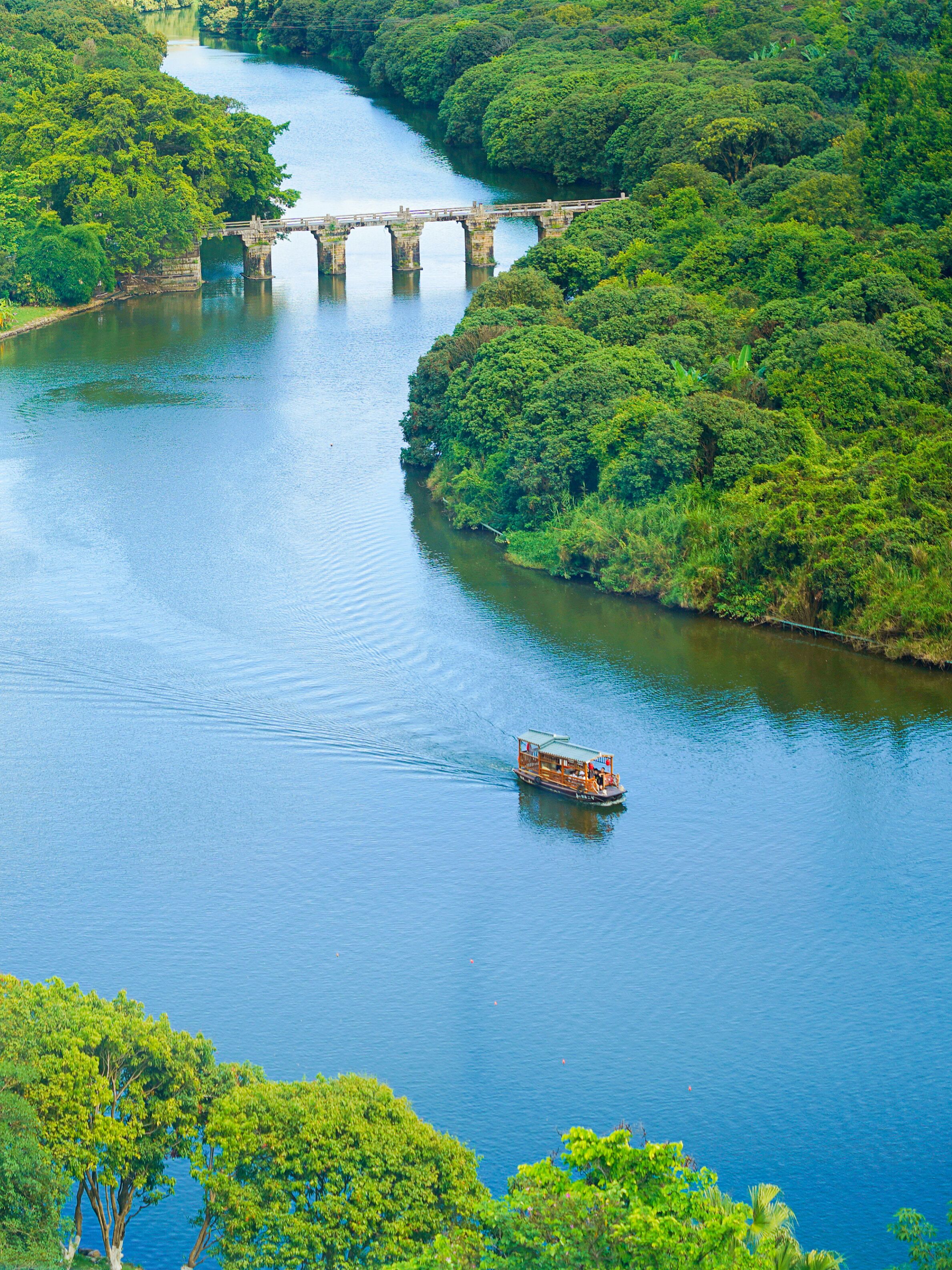 A river with a bridge and a boat.