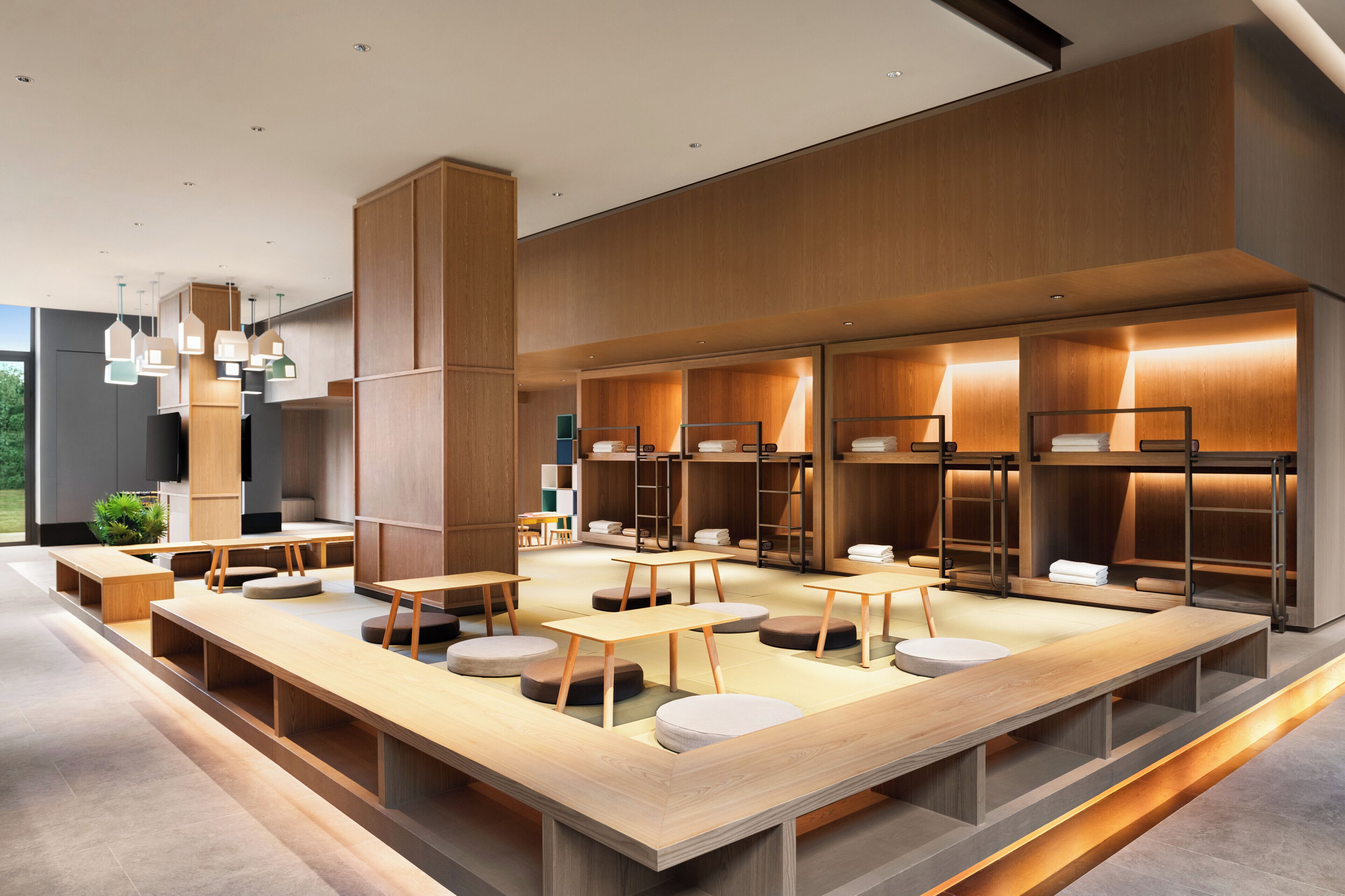 Een moderne hotellobby met houten meubels, zithoeken en inbouwopbergingen.